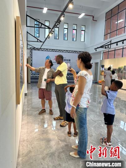 图为资佰为参展者介绍作品 木灵灵 摄