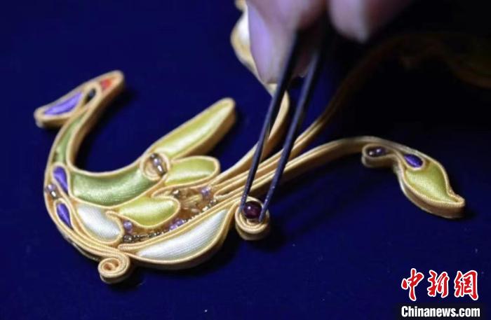 盘扣装饰在一件旗袍上创新应用引人注目。 陈璐 摄 盘扣装饰在一件旗袍上创新应用引人注目。 陈璐 摄