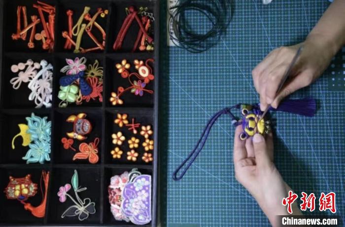 张丽娟正在给服饰手工滚边。 陈璐 摄 张丽娟正在给服饰手工滚边。 陈璐 摄