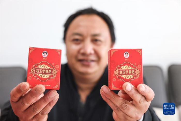 苗族村民赵玉学在家中展示自己制作的黄粑(5月31日摄)。新华社记者 欧东衢 摄