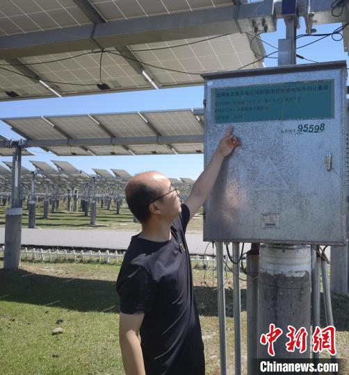 图为工作人员正在介绍光伏扶贫电站专用计量箱。　李洋 摄
