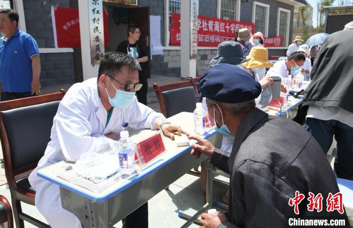 图为医生认真解答就诊人员提问。　省委统战部供图