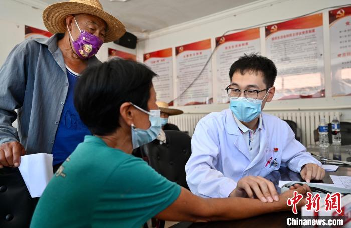 7月7日,陈东晓医生在大地村为村民诊脉。 张兴龙 摄 7月7日,陈东晓医生在大地村为村民诊脉。 张兴龙 摄