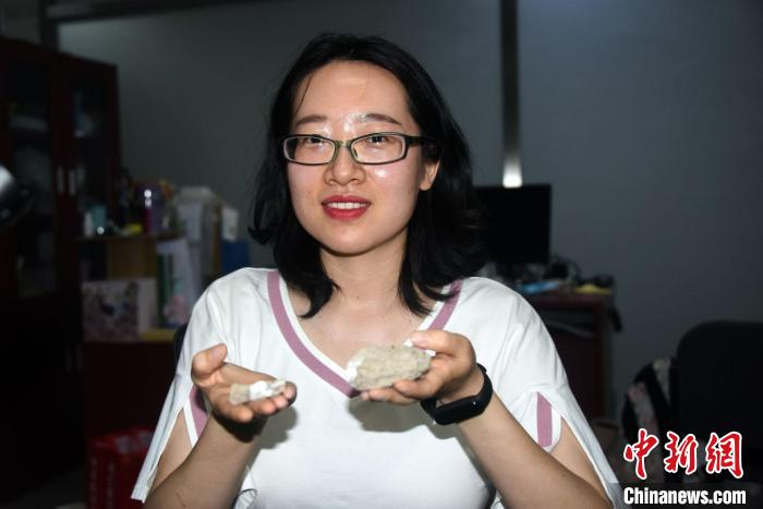 论文第一作者李颖展示介绍用于此次研究的哈密翼龙蛋壳化石标本材料。　<a target='_blank' href='/'>中新社</a>记者 孙自法 摄